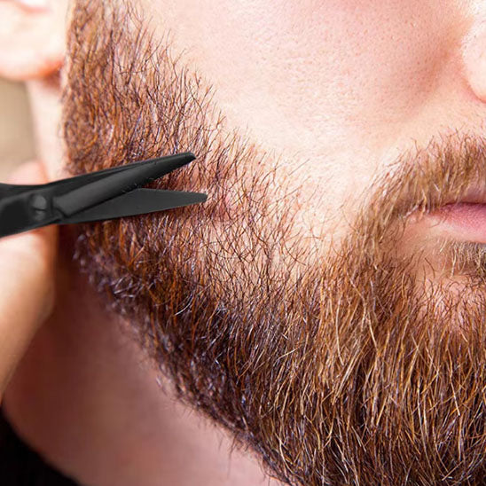 un homme se tillant soigneusement la barbe avec le ciseaux précision