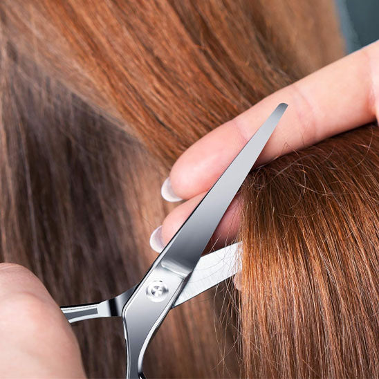 femme taillant ses cheveux avec le ciseaux précision