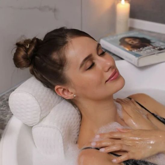 une femme savourant son bain avec le coussin de bain spa et un livre à côté