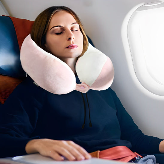 une femme se reposant dans un avion portant un oreiller ergonomique