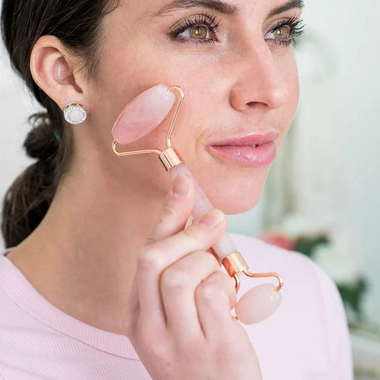 femme utilisant le rouleau de massage visage sur une peau propre