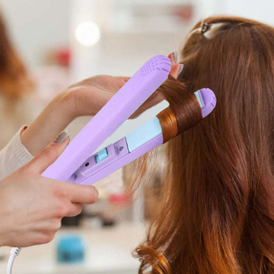 une coiffeuse faisant des boucles à sa cliente avec le mini fer à lisser