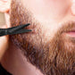 un homme se tillant soigneusement la barbe avec le ciseaux précision