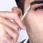 un homme se taillant précieusement les sourcils avec le ciseaux précision