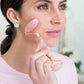 femme utilisant le rouleau de massage visage sur une peau propre 