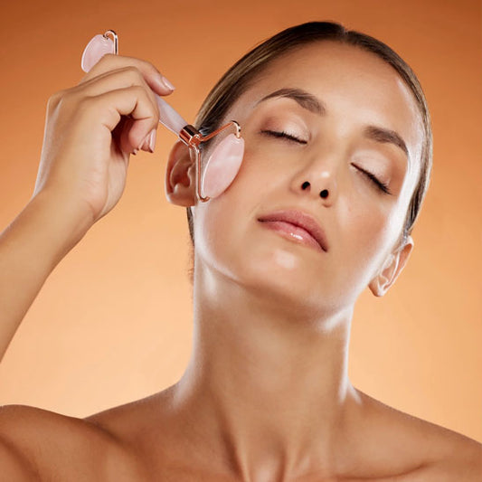 une belle femme utilisant le rouleau sur un visage propre et soignée